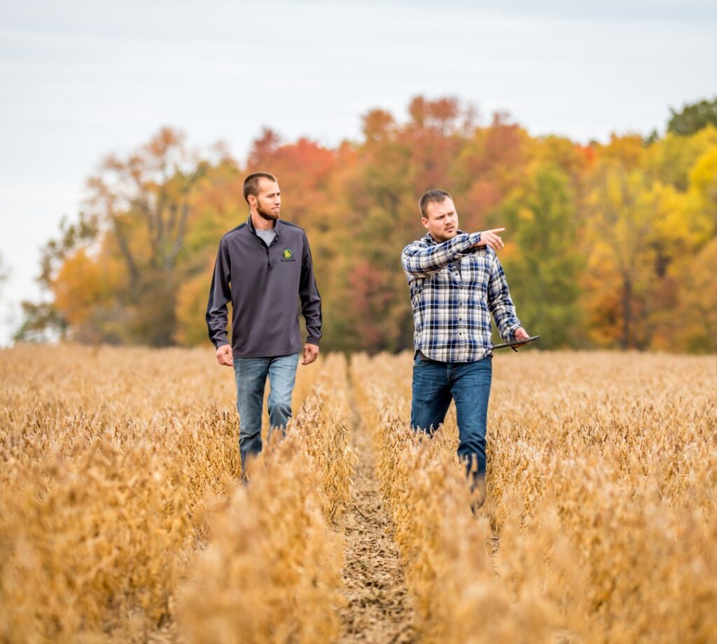 Two farmers walking through a field